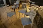 Set of four vintage wooden chairs and blue geometric pattern tapestry