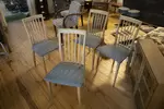 Set of four vintage wooden chairs and blue geometric pattern tapestry