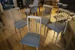 Set of four vintage wooden chairs and blue geometric pattern tapestry